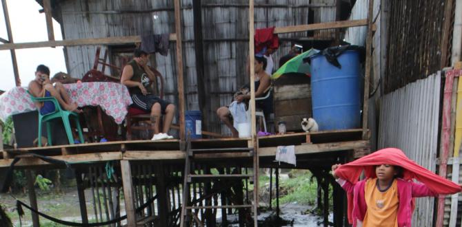 Un joven lava sus zapatos. Atrás la familia Villavicencio, quienes se quedaron sin paredes.