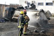 Bomberos tratan de apagar el fuego en lo que quedó del tanquero incendiado.
