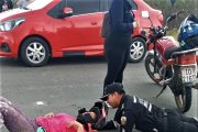 Un agente de tránsito trata de darle los primeros auxilios a la conductora caída.