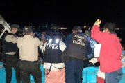 Policías y pescadores desembarcan el cuerpo que fue hallado en altamar, entre las redes de un pescador.