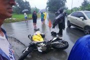 La moto y su conductor yacen en la calzada luego del percance mortal.