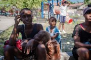 Retrato de una mujer con su hijo en brazos que asegura esperar a que retorne la paz para regresar a su hogar, durante una entrevista con Efe, hoy, en Puerto Príncipe (Haití). La guerra entre bandas en el área metropolitana de Puerto Príncipe ha obligado a miles de haitianos a huir a zonas más seguras, pero su llegada está generando recelo en los lugares de acogida, donde algunos son rechazados por el temor a que haya bandidos entre los desplazados. Los enfrentamientos entre las pandillas 400 Mawozo y Chen Mechan, que se desataron el pasado 24 de abril, han obligado a por lo menos 9.000 personas a abandonar sus domicilios en las últimas semanas, según el último balance de Naciones Unidas, divulgado la semana pasada. EFE/ Johnson Sabin