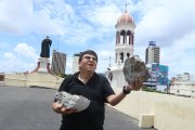 El padre Wilson Malavé sostiene los fragmentos de la cúpula de la iglesia San Agustín que se han caído.