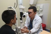 Edwin Villacís, responsable del departamento de Oftalmología del Hospital de Niños Francisco de Icaza Bustamante, revisa los ojos a un paciente escolar.