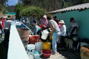 Los vecinos colaboran para abastecerse de agua para los próximos días.