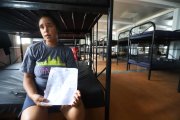 La venezolana Dugleidis muestra el informe del estado de salud de su bebé, tras haber sido violada.