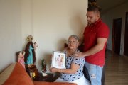 Madre e hijo miran el retrato de Cristina embarazada semanas antes del crimen.