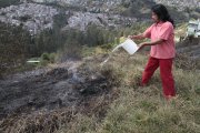 María del Carmen arroja agua para evitar que pequeños focos de humo se expandan.