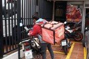 Los repartidores esperan por los pedidos en las aceras o en parques.