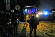 Los pasajeros esperan los buses en una oscuridad tenebrosa.