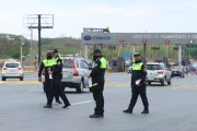Agentes de la Comisión de Tránsito del Ecuador durante un operativo de control en la carretera.