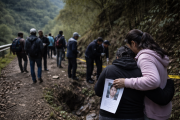 Recreación: familiares y voluntarios participan en una jornada de búsqueda en una zona montañosa, mientras una madre sostiene la fotografía de su hijo desaparecido.