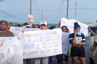 Manifestantes en Esmeraldas exhiben carteles durante la protesta por el derrame de crudo en Quinindé, reclamando indemnizaciones y reparación por los daños ambientales.