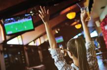 pretty-girl-fanatico-futbol-vaso-cerveza-manos-viendo-futbol-bar-deportivo_74906-1772