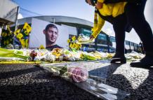 A FC Nantes supporter puts yellow flowers in front of the portrait of