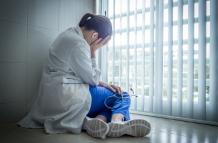 depressed-female-doctor-sitting-in-despair-near-hospital-window-healthcare-and-sorrow-concept