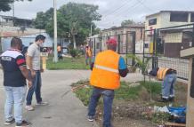 Moradores y policías limpian las aceras de un parque en el Guasmo sur de Guayaquil.