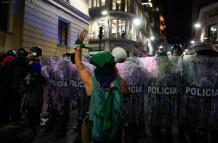 Mujer frente a los policías en marcha por el 8M en Quito.