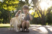 nino-sonriente-tiro-completo-perro-parque