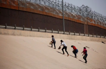 Referencial. Migrantes intentan cruzar el muro para ir a Estados Unidos.