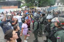 Personas reclaman frente a integrantes de la Guardia Nacional Bolivariana (GNB).