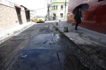 En la calle Villonaco, los vecinos sortean el charco de agua que se forma por la fuga.