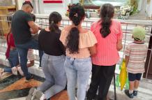 Fieles arrodillados contemplan y oran a Santa Narcisa de Jesús en su santuario.