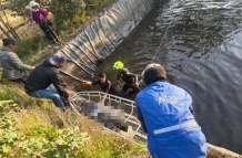 Bomberos locales mientras sacan el cuerpo de un menor de un reservorio en Guamote.