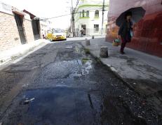 En la calle Villonaco, los vecinos sortean el charco de agua que se forma por la fuga.