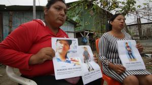 Olimpia Cruz y Mireya Pincay  muestran las hojas impresas con los rostros de sus seres queridos. Piden ayuda a la Policía y a la ciudadanía.