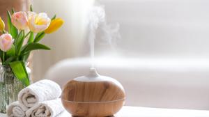 spa-composition-with-the-aroma-of-modern-oil-diffuser-with-body-care-products-twisted-white-towels-spring-greens-and-flowers-spa-concept-for-body-and-health-care