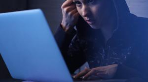 young-woman-breaching-network-security-system-and-stealing-data-from-laptop-at-night