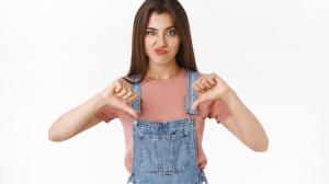 disappointed-skeptical-arrogant-attractive-woman-in-overalls-t-shirt-smirking-unsatisfied-showing-thumbs-down-and-frowning-in-disagreement-express-dislike-judge-something-awful