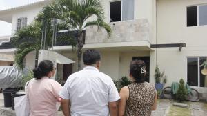 Vecinos observan, consternados, la casa donde el lunes 20 de marzo tres miembros de una familia murieron intoxicados.