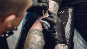hombre-haciendo-tatuaje-salon-tatuajes