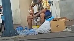Hombre llena botella usada con agua en Babahoyo