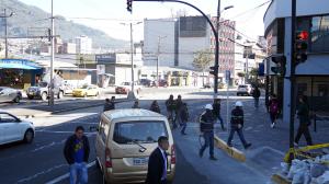 Algunos conductores, pese a la luz roja del semáforo y que peatones están cruzando, avanzan con sus vehículos.