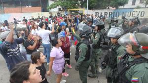 Personas reclaman frente a integrantes de la Guardia Nacional Bolivariana (GNB).