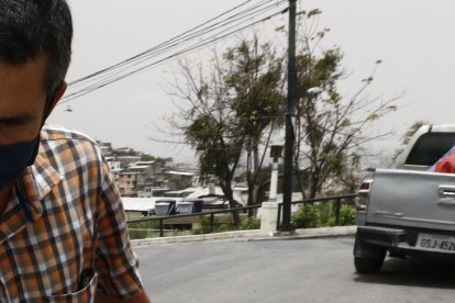 Un ciudadano de Guayaquil retira las cenizas del volcán en un barrio de Guayaquil.