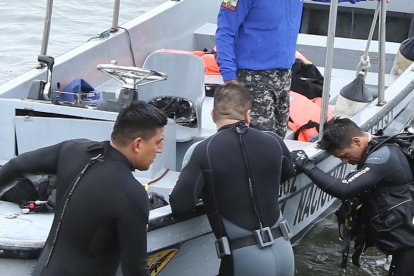 Buzos del Grupo de Intervención y Rescate (GIR), de la Policía Nacional, realizan la búsqueda del muchacho.