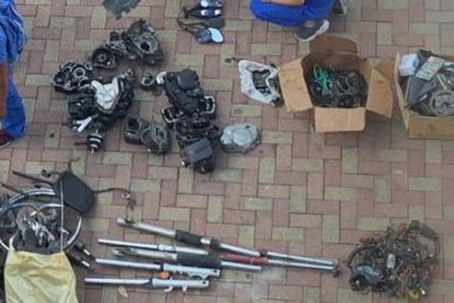 Miembros de la Policía clasificando las motos y piezas de dudosa procedencia, halladas en una vivienda.