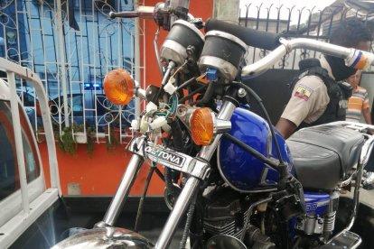 La motocicleta en la que se movilizaban dos de los sujetos arrestados con un arma.