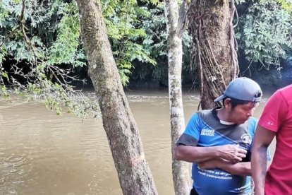 Rescatistas junto al cuerpo del infortunado que habría caído accidentalmente a un río.
