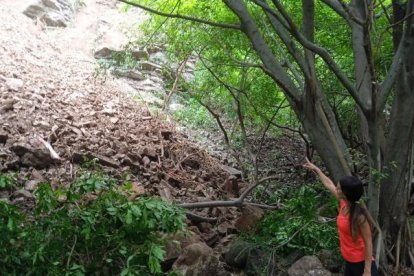 Una moradora señala el punto donde ocurrió el deslizamiento de tierra