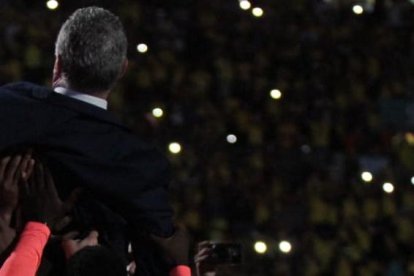 Gustavo Alfaro levantado por los jugadores de Ecuador.