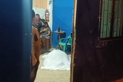 Los familiares cubrieron el cadáver de Silvia con una sábana. En el fondo una persona llora por la fallecida.