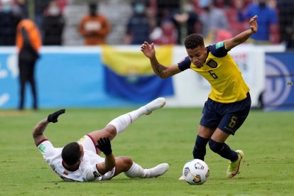 Byron Castillo (d) de Ecuador disputa el balón con José Martínez de Venezuela hoy, en un partido de las eliminatorias sudamericanas.