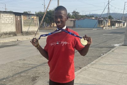 Jorge Quiñónez en las calles de Socio Vivienda 2, mostrando las medallas que va logrando en el atletismo adaptado.