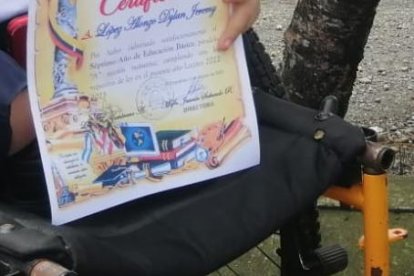 Con orgullo, Dylan muestra su diploma de mejor estudiante de su salón.