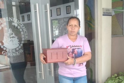 Dayanna Herrera sostiene el cofre donde la reposan las cenizas de Victoria.